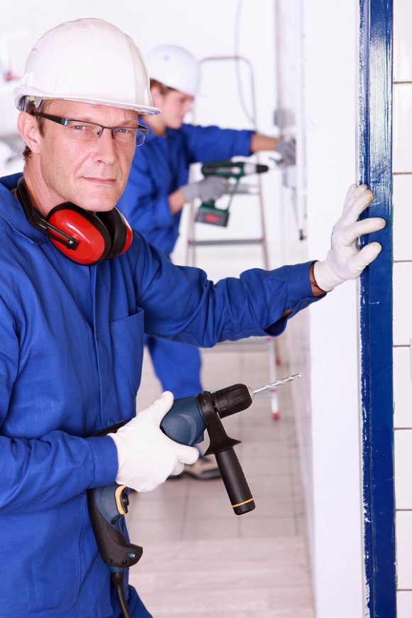 The technician holding drill in workplace at Tampa, FL