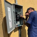 Hawkins Service Co. electrician working on a home's exterior electrical panel