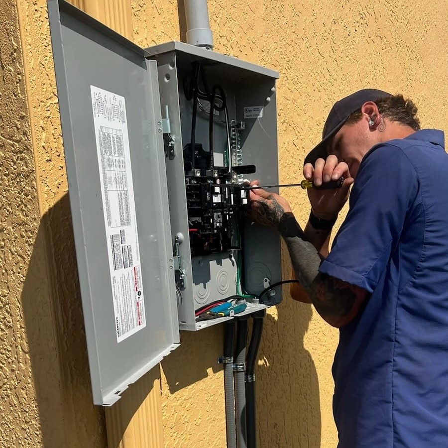 Hawkins Service Co. electrician working on a home's exterior electrical panel