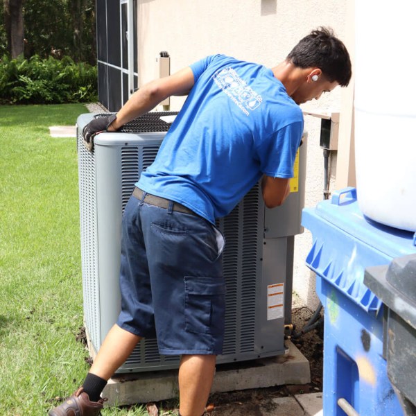 A technician installing an outdoor AC unit