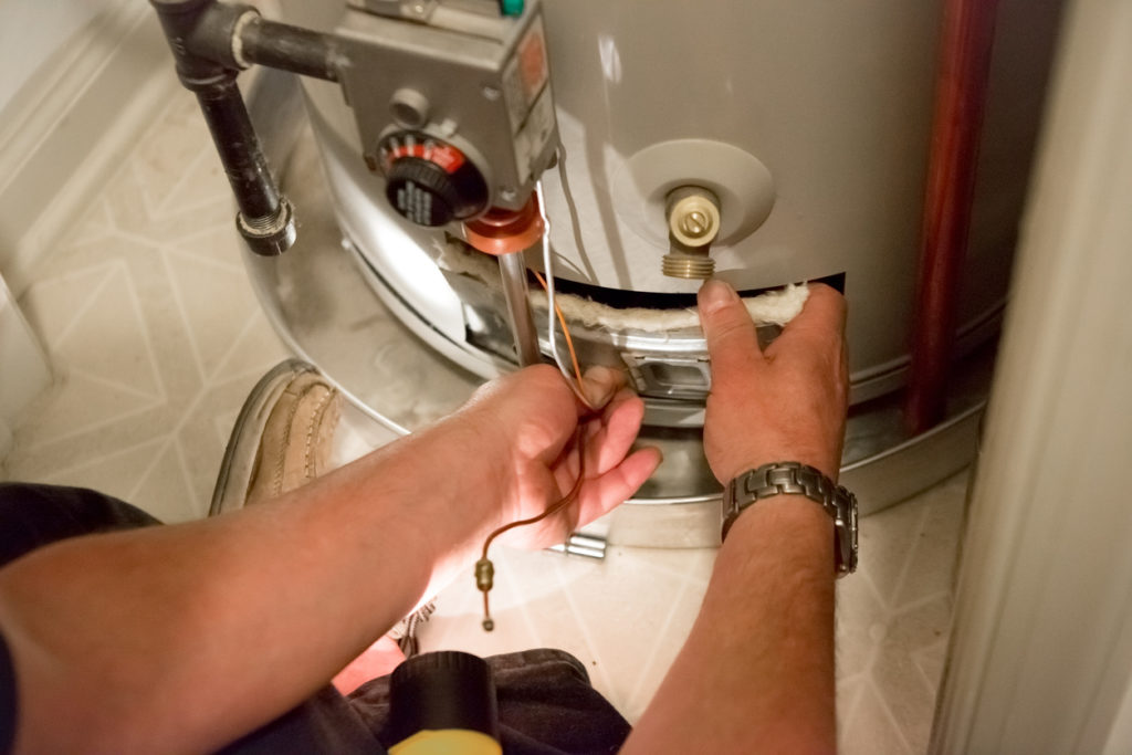 Plumber working on a storage tank water heater