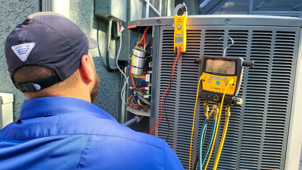A technician looking at a ac unit condenser unit