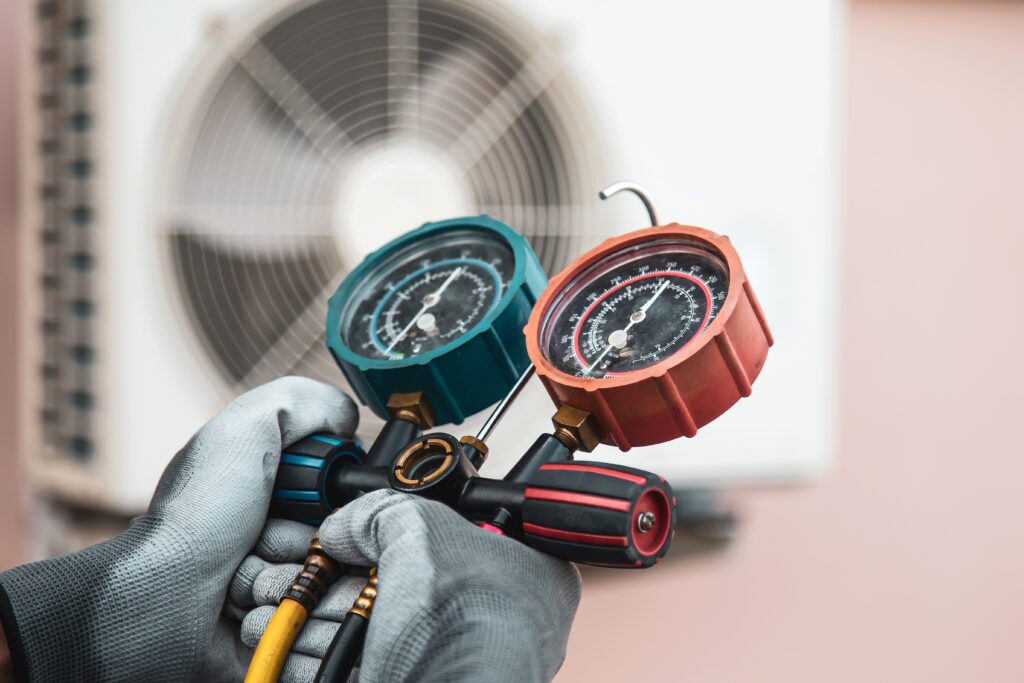 Technician using an AC repair pressure test gauge.