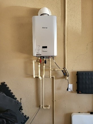 Tankless water heater installation in residential garage.