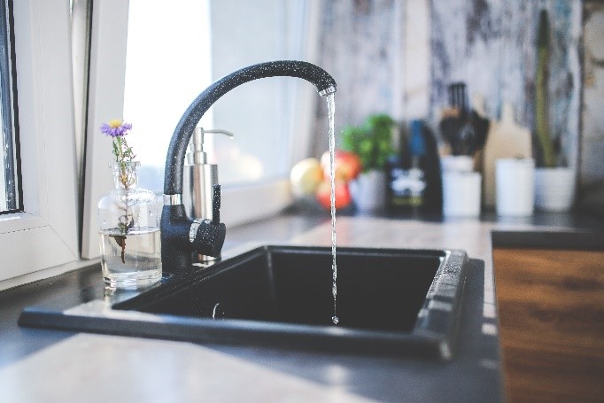 Kitchen sink pouring purified water – plumbing appliances for water filtration