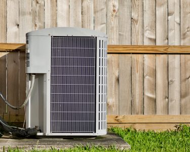 Central air conditioning unit in a residential backyard